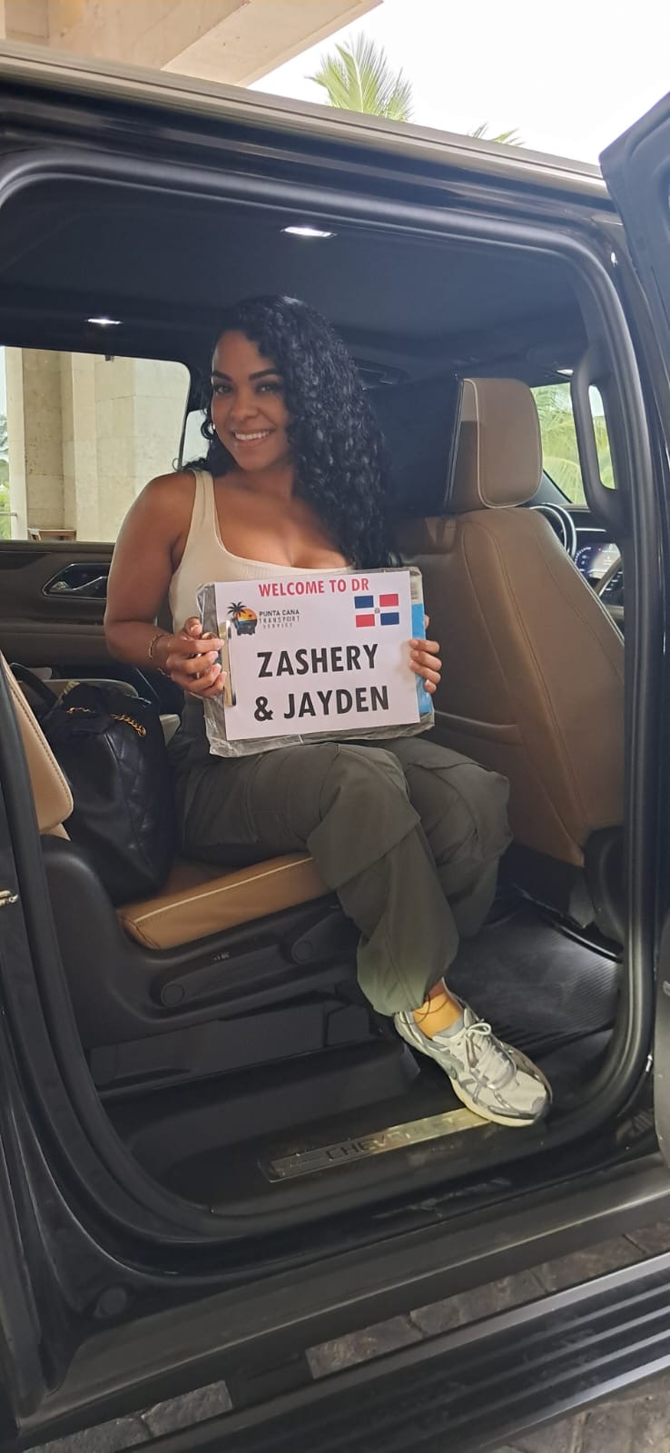 A client holding her personal welcome sign inside the Suburban